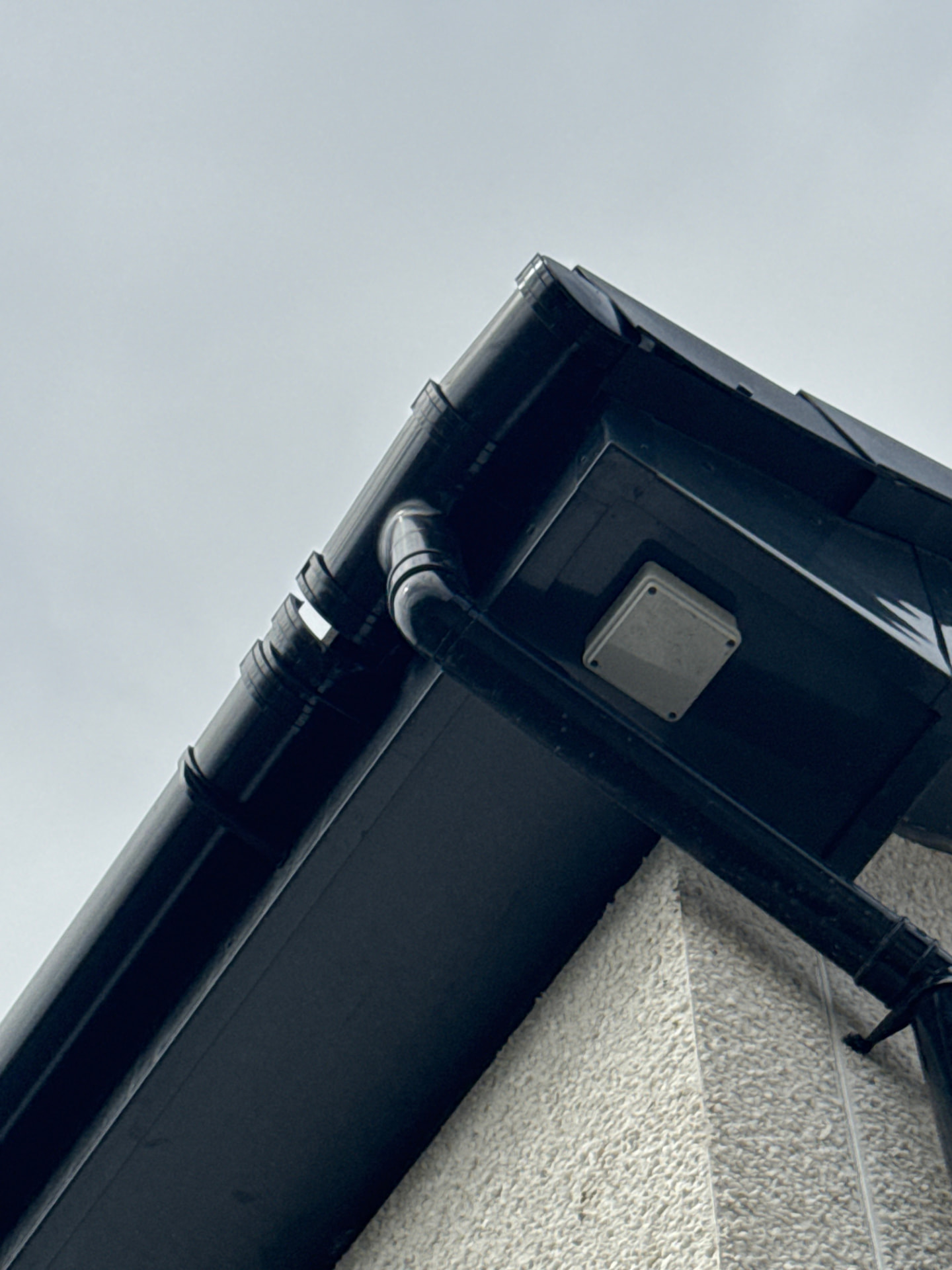 Gutter, fascia and downpipe junction inspected at the corner of a new build home