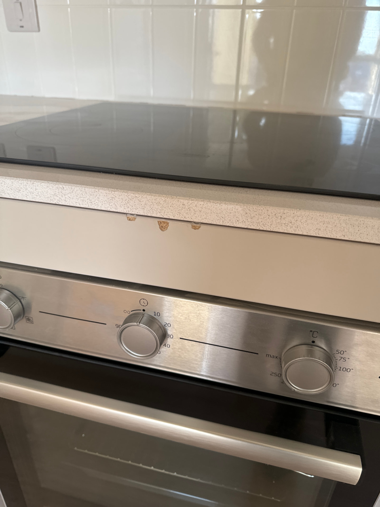 Chipped kitchen worktop edge recorded beside the oven during a new build snagging inspection