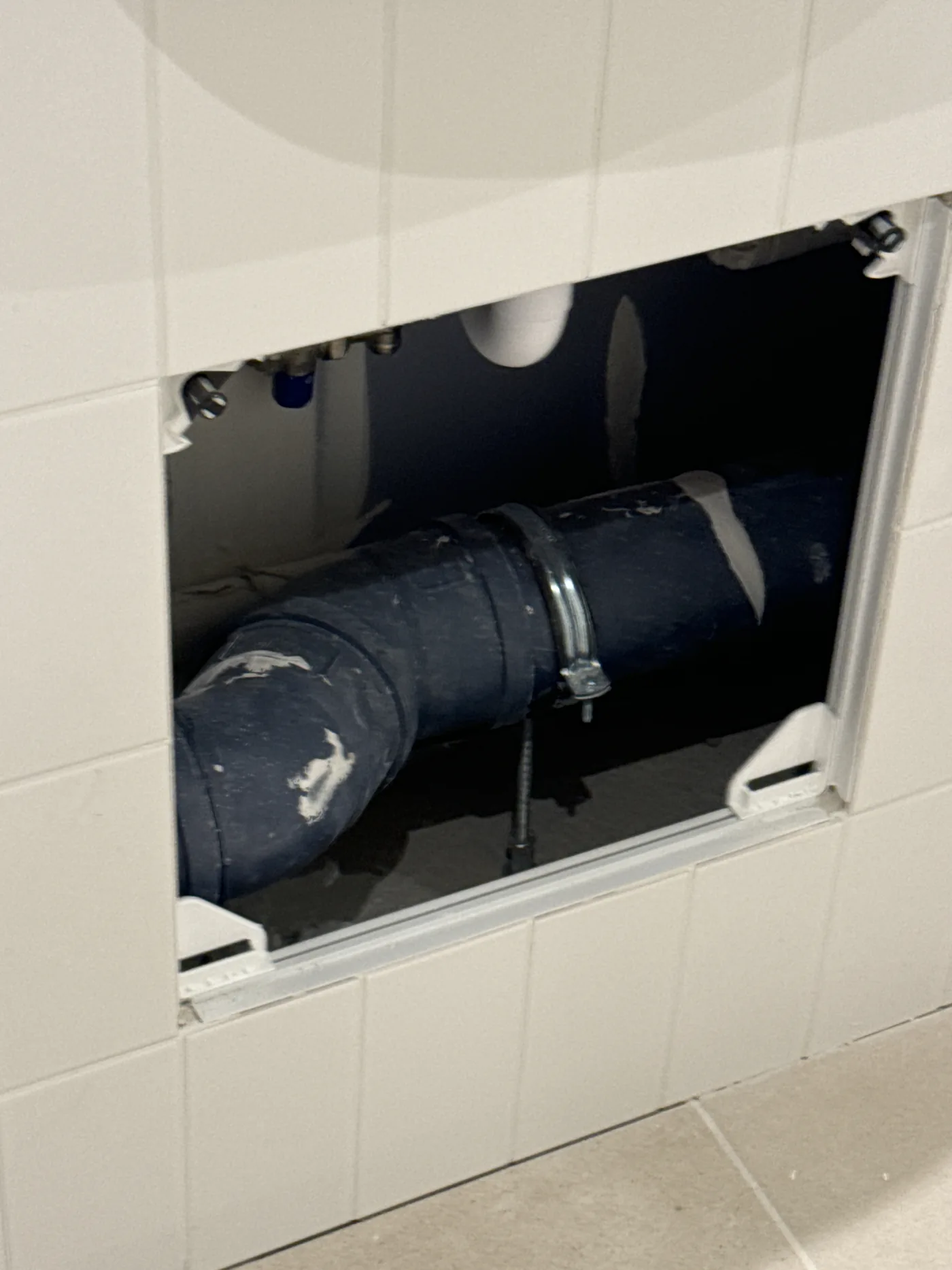 MVHR ductwork inspected behind a service access panel in a new build home